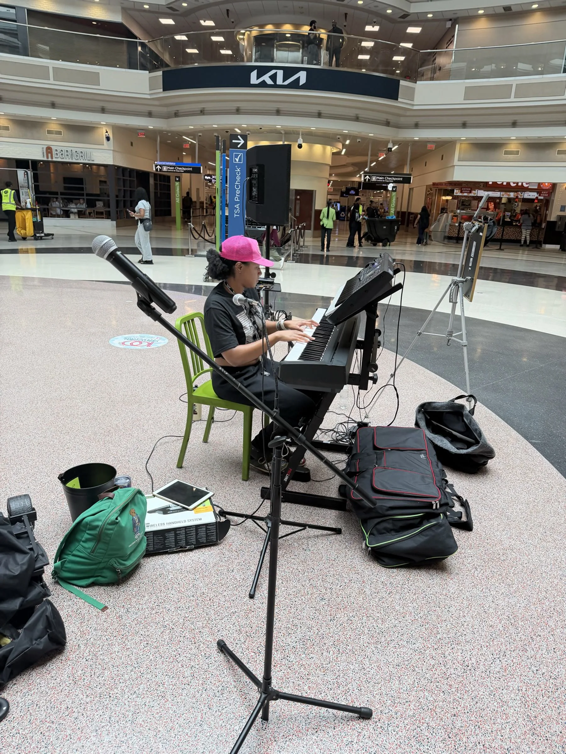 A musician performing for travelers in the atrium at Hartsfield-Jackson Atlanta International Airport